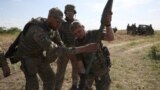 Ukrainian servicemen manipulate a rocket launcher during a training exercise not far from front line in the Donetsk region, June 8, 2023.