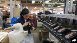 FILE - A woman works in a shoe factory in Leon, Mexico, Feb. 7, 2023. 