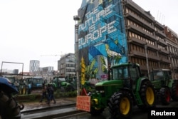 Deretan traktor terlihat saat aksi protes petani Eropa atas tekanan harga, pajak dan peraturan ramah lingkungan, pada hari pertemuan Menteri Pertanian Uni Eropa di Brussels, Belgia 26 Februari 2024. (REUTERS/Yves Herman0