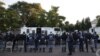 FILE - South African Police Service officers line up near temporary dwelling built by foreign migrants in front of the United Nations High Commissioner for Refugees offices in Pretoria on April 21, 2023 ahead of a forced eviction.