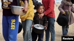 Displaced Palestinian children wait to receive free food at a tent camp as the conflict between Israel and Hamas continues, in Rafah in the southern Gaza Strip, Feb. 27, 2024. 