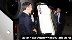 French President Emmanuel Macron shakes the hand of Mohammed bin Abdulaziz bin Saleh al-Khulaifi, the Qatari Minister of State at the Ministry of Foreign Affairs, in Doha, Qatar, Dec. 2, 2023.