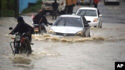Motorists wade through a flooded road in Mombasa, Kenya, after a heavy downpour on Nov.3, 2023. 