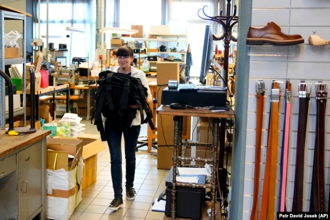 FILE - A Ukrainian worker carries new body armor at a shop in Prague, April 21, 2022. (AP Photo/Petr David Josek)