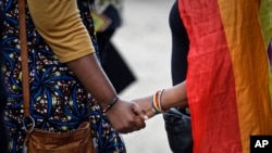 FILE - Activists from the LGBTQ community and their supporters commiserate after a ruling by the High Court upheld sections of the penal code that criminalize same-sex relations in Nairobi, Kenya, on May 24, 2019. 