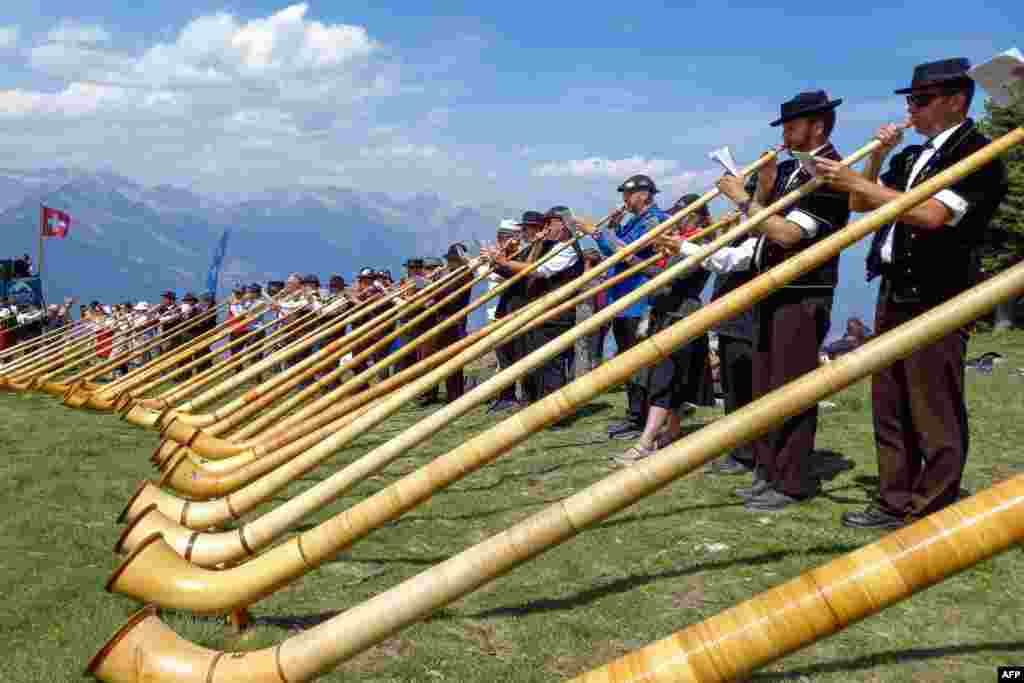 Approximately 100 Alphorn players perform on the final day of the 22th International Alphorn Festival on the mountain pasture of Tracouet, 2,200 meters up in the Swiss Alps above Nendaz.