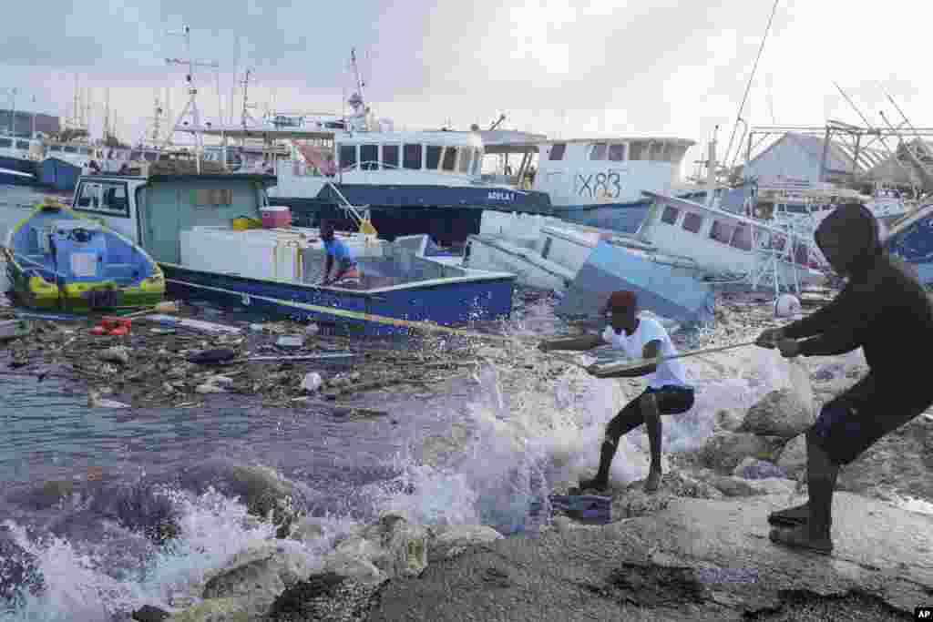 Fishermen pull a boat damaged by Hurricane Beryl to the dock at the Bridgetown Fisheries in Barbados, July 1, 2024.