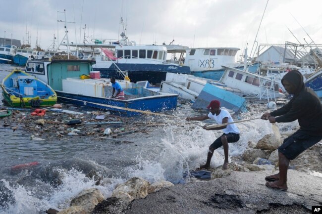 Fishermen pull a boat damaged by Hurricane Beryl back to the dock at the Bridgetown Fisheries in Barbados, July 1, 2024. (AP Photo/Ricardo Mazalan)