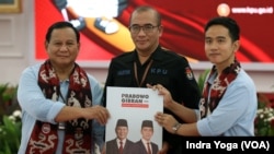 Calon presiden Prabowo Subianto dan calon wakil presiden Gibran Rakabuming memberikan berkas pendaftaran kepada Ketua KPU, Hasyim Asyari pada Rabu (25/10) untuk mendaftar sebagai pasangan dalam Pilpres 2024. (VOA/Indra Yoga) 