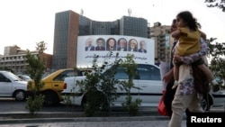 FILE - A billboard with portraits of presidential candidates is displayed on a street in Tehran, Iran, June 17, 2024. (Majid Asgaripour/West Asia News Agency via Reuters)
