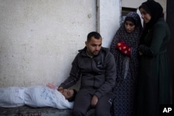 Palestinians mourn a child killed in the Israeli bombardment of the Gaza Strip at a hospital morgue in Rafah, Feb. 12, 2024.