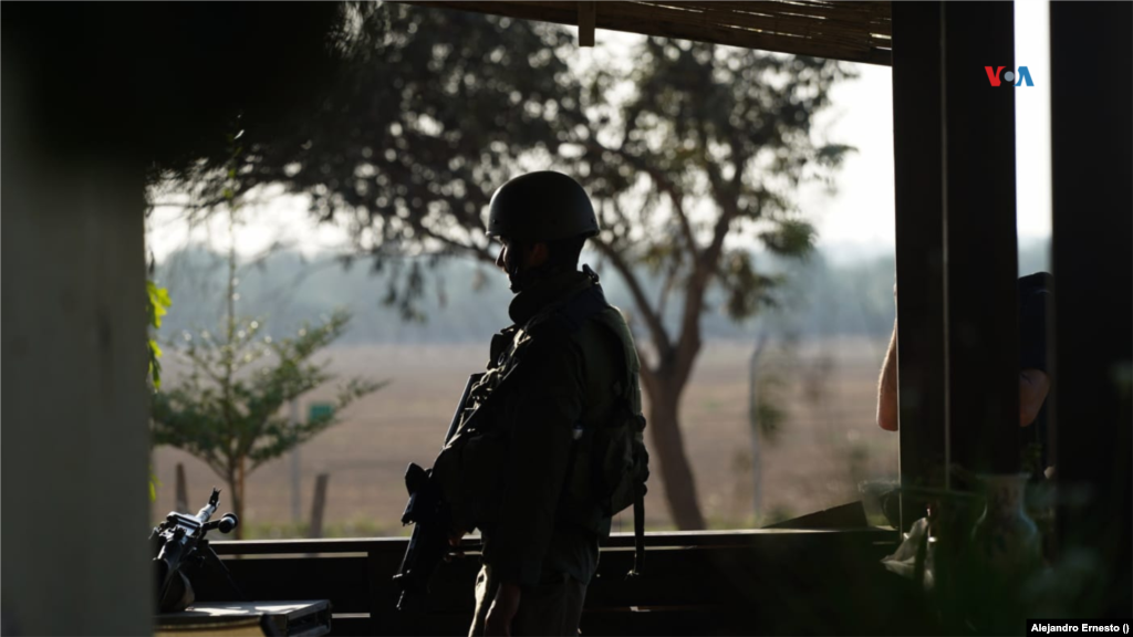 Un soldado israelí monta guardia en una de las viviendas del kibutz Holit. Al fondo, dos kilómetros más allá, la frontera con Gaza.