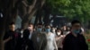 Commuters, many wearing face masks, walk along a street in the central business district during the morning rush hour in Beijing, May 26, 2023.
