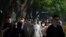 Commuters, many wearing face masks, walk along a street in the central business district during the morning rush hour in Beijing, May 26, 2023.