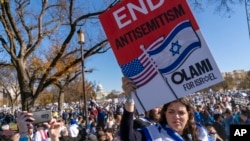 Žena na protestu podrške Izraelu u Washingtonu drži transprent protiv antisemitizma.