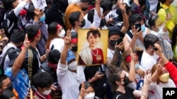 FILE - Myanmar nationals living in Thailand hold a picture of former Myanmar leader Aung San Suu Kyi during a protest marking the two-year anniversary of Myanmar's military takeover, in Bangkok, Thailand, Feb. 1, 2023.