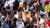 FILE - Myanmar nationals living in Thailand hold a picture of former Myanmar leader Aung San Suu Kyi during a protest marking the two-year anniversary of Myanmar's military takeover, in Bangkok, Thailand, Feb. 1, 2023.