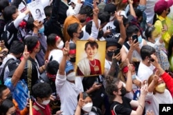 Warga negara Myanmar yang tinggal di Thailand memegang foto mantan pemimpin Myanmar Aung San Suu Kyi pada aksi protes menandai peringatan dua tahun kudeta militer Myanmar, di Bangkok 1 Februari 2023. (Sakchai Lalit/AP)