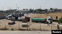 Trucks carrying aid wait to exit, on the Palestinian side of the border with Egypt, as the conflict between Israel and Palestinian Islamist group Hamas continues, in Rafah in the southern Gaza Strip, Oct. 21, 2023.