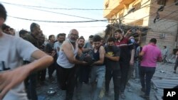 Palestinians evacuate survivors after an Israeli strike on the Gaza Strip in Rafah on Nov. 6, 2023.