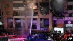 Firefighters extinguish the fire inside an apartment following a massive explosion in the southern suburb of Beirut, Lebanon on Tuesday, January 2, 2024.