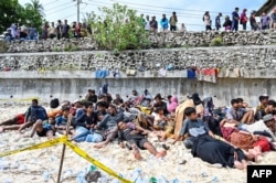 Pengungsi Rohingya yang baru tiba beristirahat di pantai Pulau Sabang, Aceh, 22 November 2023. (Foto: CHAIDEER MAHYUDDIN/AFP)