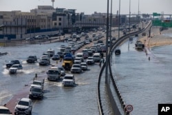 Kendaraan melewati genangan banjir akibat hujan lebat di Dubai, Uni Emirat Arab, 18 April 2024. (AP/Christopher Pike)