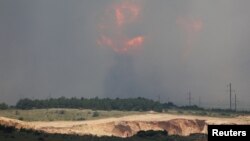 ARCHIVO - El humo y las llamas surgen de una explosión durante un incendio en un campo de entrenamiento militar en el distrito de Kirovske, Crimea, el 19 de julio de 2023.