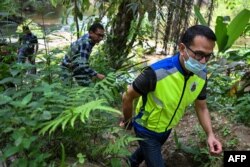 Petugas imigrasi memeriksa sungai dekat pusat penahanan imigrasi di Bidor di negara bagian Perak utara Malaysia pada 2 Februari 2024, setelah lebih dari 100 pengungsi Rohingya melarikan diri dari fasilitas tersebut. (Foto: AFP)