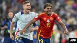 Penyerang Spanyol Fermin Lopez dan penyerang Spanyol Lamine Yamal merayakan akhir pertandingan sepak bola semifinal Euro 2024 antara Spanyol dan Prancis di Munich Football Arena di Munich pada 9 Juli 2024. (Foto: AFP)