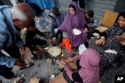 Palestinians displaced by the Israeli bombardment of the Gaza Strip cook in Nusseirat refugee camp, central Gaza Strip, Monday, Nov. 27, 2023. (AP Photo/Hatem Moussa)