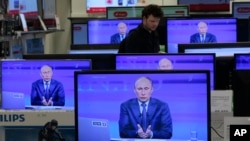 ARCHIVO - El presidente ruso Vladimir Putin es visto en las pantallas de televisión de una tienda mientras habla durante un programa anual de llamadas en la televisión rusa "Conversación con Vladimir Putin" en Moscú el jueves 25 de abril de 2013.