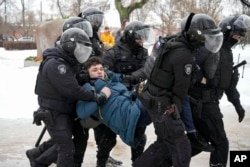 Police detain a man who wanted to honor Alexei Navalny in St. Petersburg, Russia, Feb. 17, 2024.