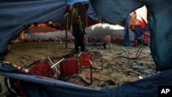 Seorang polisi Pakistan berjaga di lokasi serangan bom bunuh diri pada Minggu di distrik Bajur, Khyber Pakhtunkhwa, Pakistan, Senin, 31 Juli 2023. (Foto: AP)