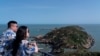 资料照片：一对游客在妈祖观海。(2023年4月9日)