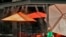 A woman walks under misters outside a restaurant, July 12, 2023 in Gilbert, Ariz. Even desert residents accustomed to scorching summers are feeling the grip of an extreme heat wave smacking the U.S. Southwest this week.