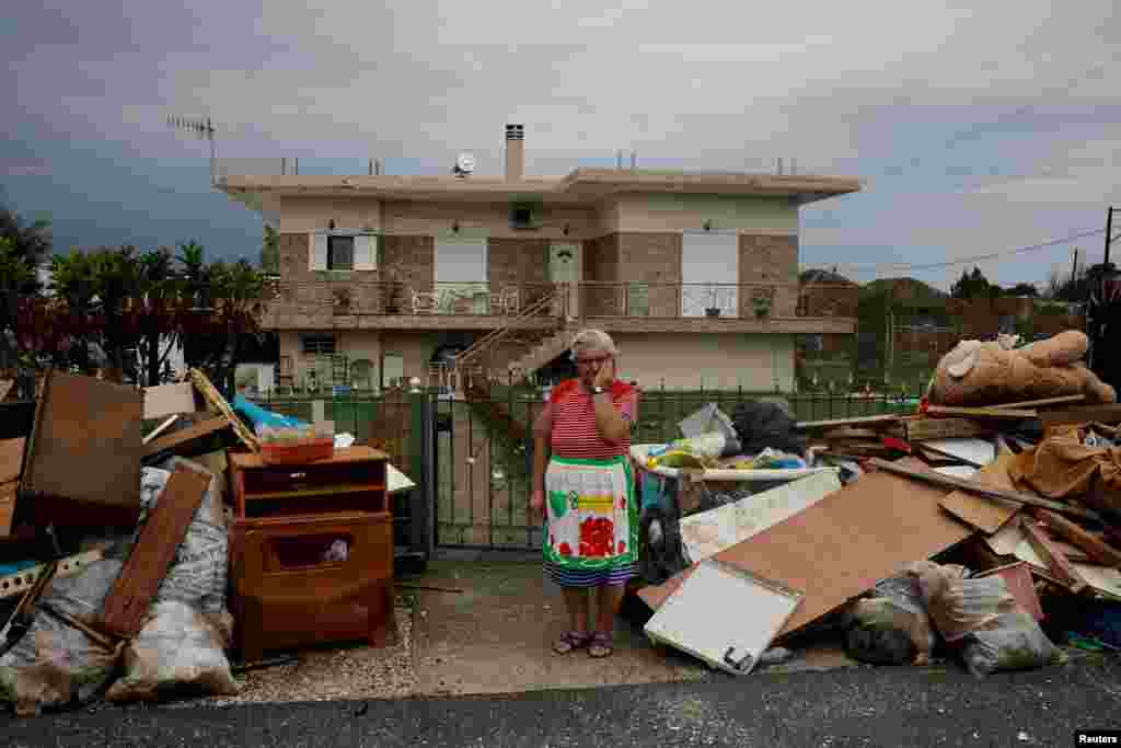 Anastasia Tsagkarakaki, 60, stands by her belongings, removed from her flooded house, in the aftermath of storm Daniel in the village of Koskinas, Greece. Tsagkarakaki lost her crops and 120 chickens in the storm.