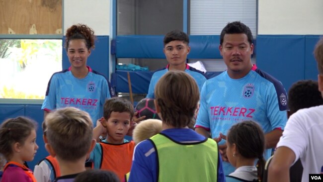 Kevin Chin (kanan belakang) dan Patricia Tomanon (kiri belakang) melatih para pemain muda dari usia lima tahun di pusat latihan pesepak bola Trekkerz Performance Training di Florida Selatan (VOA Indonesia)