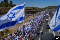 Miles de israelíes marchan por una carretera hacia Jerusalén en protesta por los planes del gobierno de Netanyahu de reformar el sistema judicial, cerca de Abu Gosh, Israel, el 22 de julio de 2023.