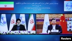 Iranian President Ebrahim Raisi, together with Chinese President Xi Jinping, attend the 23rd Shanghai Cooperation Organisation Council of Heads of State (SCO) Summit via video link, at the Office of the President of Iran, in Tehran, July 4, 2023. 