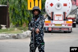 FILE - A police officer gestures to stop a motorist on Lagos expressway, as he enforces a restriction imposed on movement of motorists during local elections, in Lagos, on March 18, 2023.