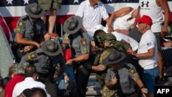 A person is removed by state police from the stands after guns were fired at Republican candidate Donald Trump at a campaign event at Butler Farm Show Inc. in Butler, Pennsylvania, July 13, 2024.