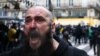 FILE: An injured man reacts during a demonstration as part of the ninth day of nationwide strikes and protests against French government's pension reform, in Paris, France, March 23, 2023. 