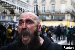An injured man reacts during a demonstration as part of the ninth day of nationwide strikes and protests against French government's pension reform, in Paris, March 23, 2023.
