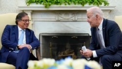 El presidente de Estados Unidos, Joe Biden, se inclina para hablarle a su homólogo de Colombia, Gustavo Petro, mientras periodistas les gritan preguntas en la Oficina Oval de la Casa Blanca, en Washington, el jueves 20 de abril de 2023.