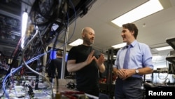 FILE - Canada's Prime Minister Justin Trudeau speaks with Xanadu Quantum Technologies CEO and founder Christian Weedbrook during a visit to the tech firm in Toronto, Jan. 23, 2023. Canada unveiled an immigration initiative to boost its tech workforce. 