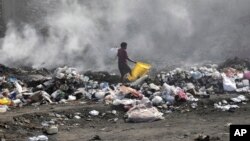 A woman walks through a landfill looking for salvageable items in Port-au-Prince, Haiti, July 1, 2023.