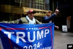 Seorang pendukung mantan Presiden Donald Trump, dan seorang pria yang menyamar sebagai mantan presiden berdiri di luar Trump Tower pada 31 Maret 2023, di New York. (Foto: AP)