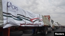 Trucks carrying humanitarian aid to Palestinians, wait on the desert road (Cairo - Ismailia) in Cairo, Egypt, on their way to the Rafah border crossing to enter Gaza, Nov.12, 2023.