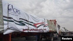 运送救援物资的卡车停在埃及首都开罗附近的公路上，等待前往通向加沙地带的拉法口岸。（2023年11月12日）